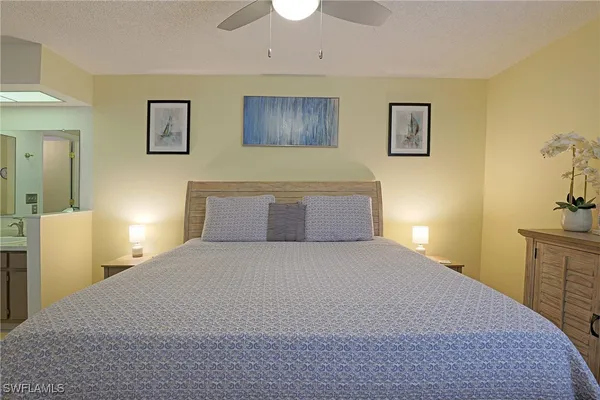 a bedroom with a large bed and a chandelier