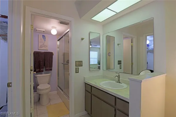 a bathroom with a sink a toilet a shower and a mirror