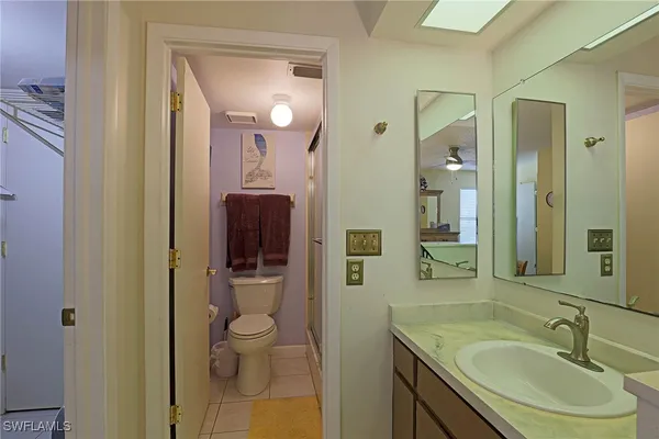 a bathroom with a granite countertop sink a toilet and shower