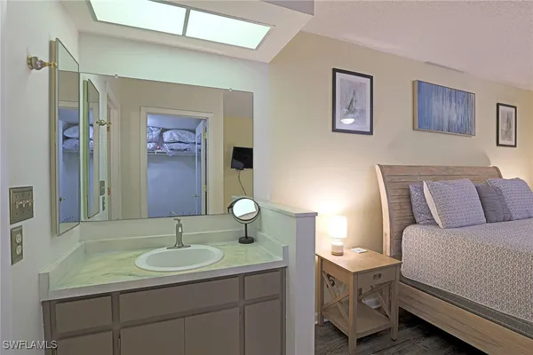 a en suite bathroom with a granite countertop sink and a mirror