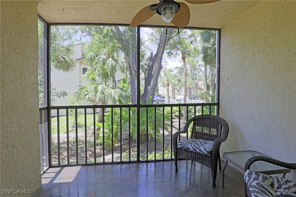 a view of a balcony with chairs and wooden floor