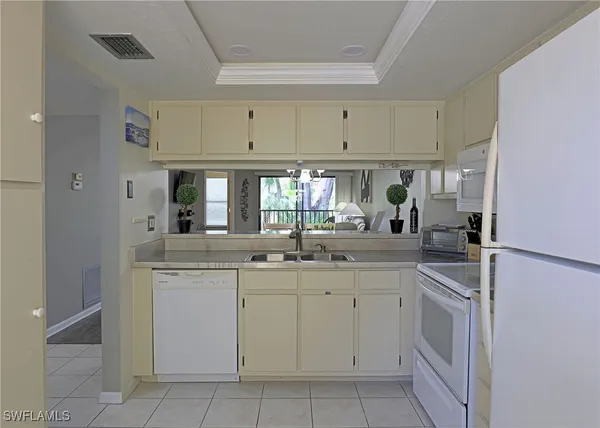 a kitchen with white cabinets appliances and a sink