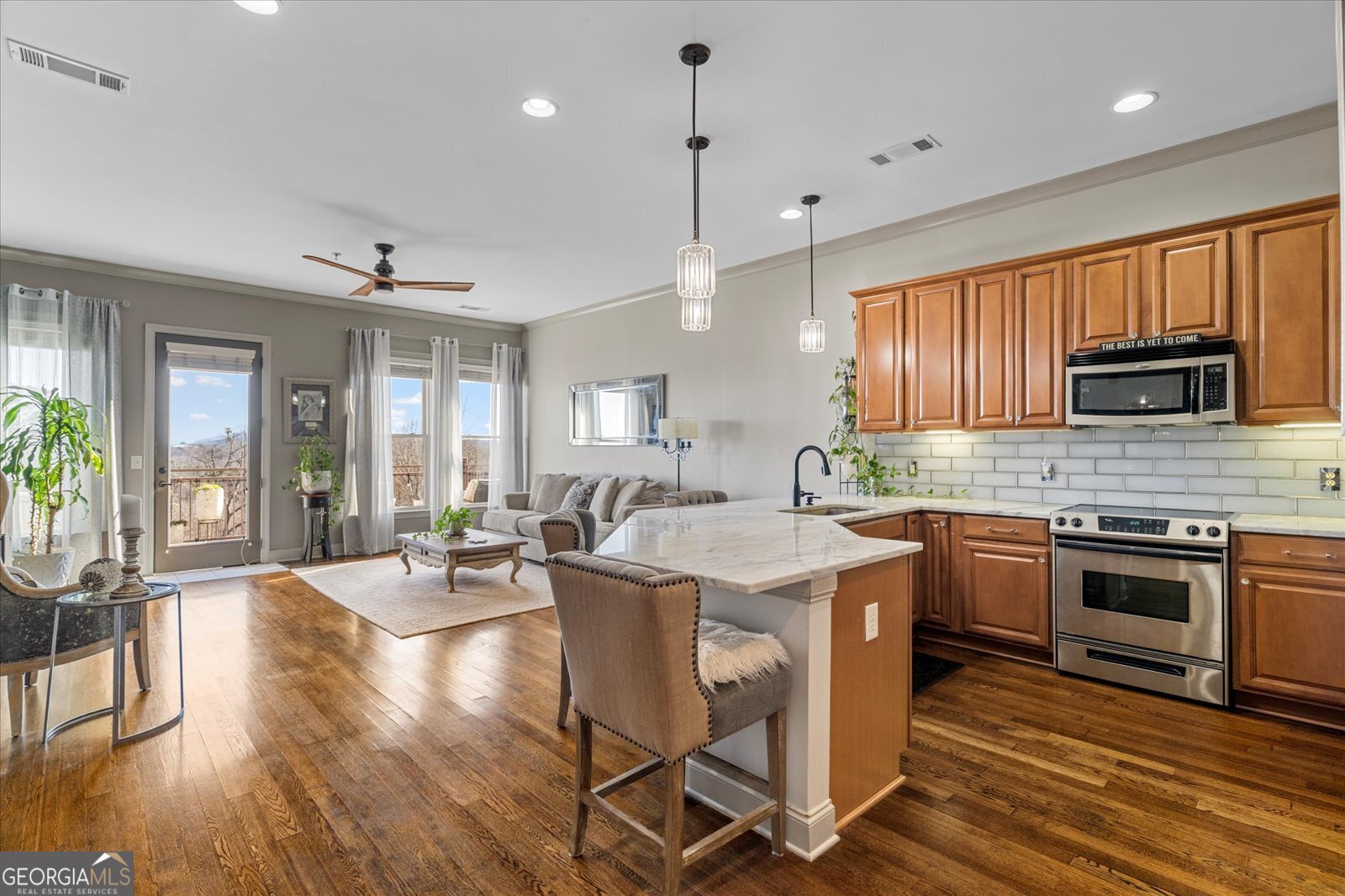 360 Chambers Street Woodstock, GA 30188 - Photo 11 of 50 a kitchen with stainless steel appliances granite countertop a stove top oven a refrigerator a sink dishwasher a dining table and chairs with wooden floor
