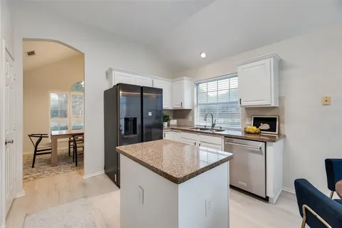 a kitchen with a refrigerator and a stove top oven
