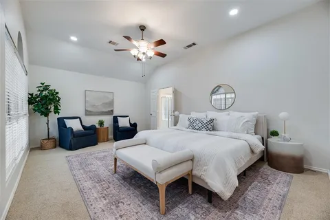 a bedroom with a bed a chandelier and a couch