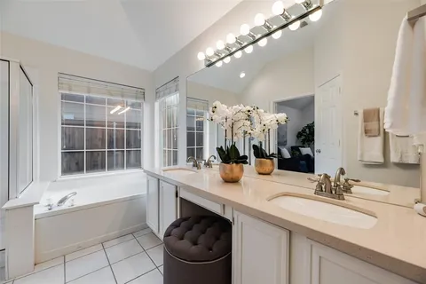 a bathroom with a sink a large mirror and a bathtub
