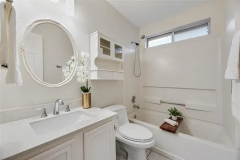 a bathroom with a granite countertop sink a toilet and a mirror