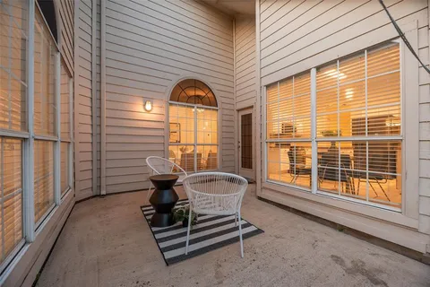 a view of a patio with a table and chairs and a barbeque