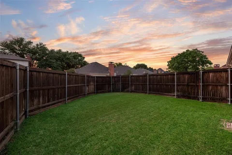a view of a backyard with wooden fence