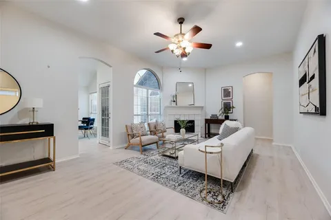 a living room with furniture a fireplace and a chandelier