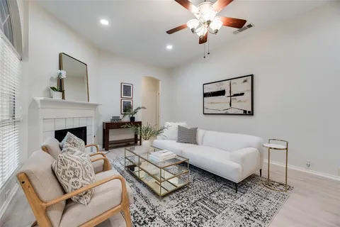 a living room with furniture a fireplace and a ceiling fan