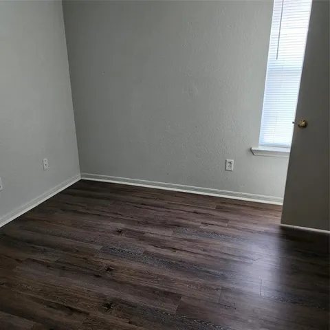 a view of wooden floor and cabinets in a room