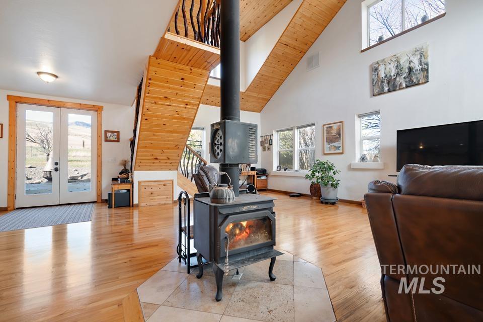 7025 Bluebird Lane Sweet, ID 83670 - Photo 12 of 46 Living area featuring a wood stove, french doors, light wood-style flooring, and high vaulted ceiling