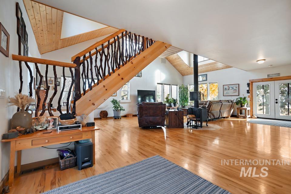 7025 Bluebird Lane Sweet, ID 83670 - Photo 13 of 46 Living area with a wood stove, french doors, wooden ceiling, wood finished floors, and plenty of natural light