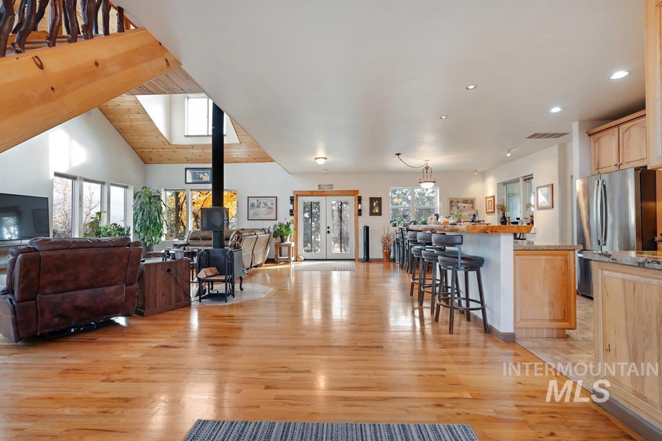 7025 Bluebird Lane Sweet, ID 83670 - Photo 14 of 46 Living area featuring light wood-type flooring, french doors, a wood stove, wood ceiling, and lofted ceiling