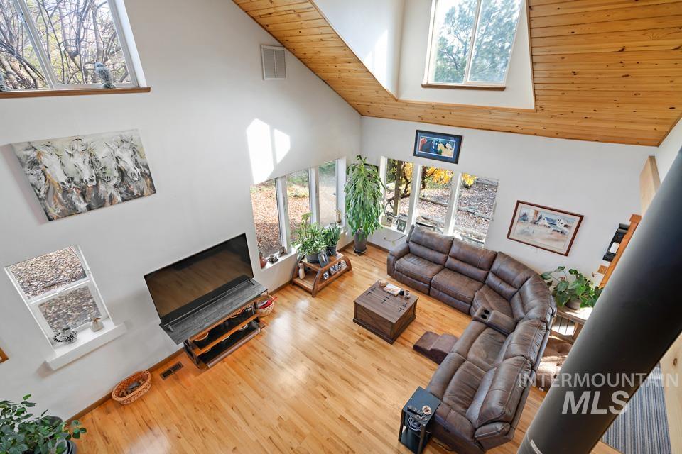 7025 Bluebird Lane Sweet, ID 83670 - Photo 31 of 46 Living room with high vaulted ceiling, wooden ceiling, wood finished floors, and a skylight