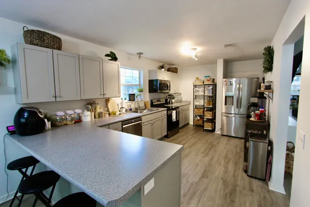 a kitchen with a refrigerator a stove a sink dishwasher and a oven with wooden floor