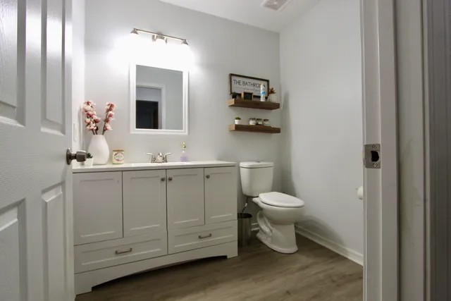 a bathroom with a toilet sink and mirror