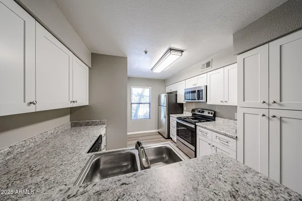 a kitchen that has a sink and a stove top oven