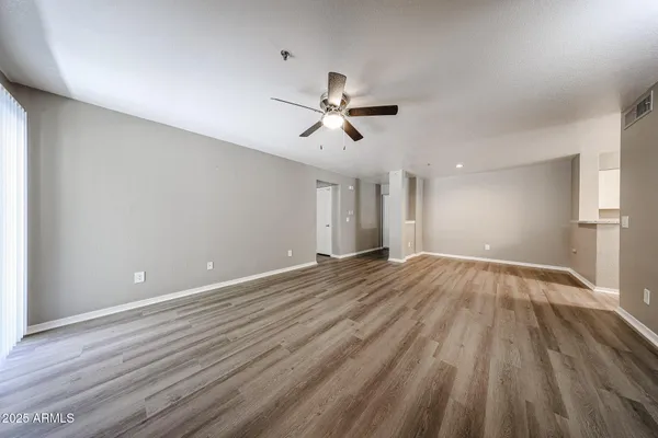 a view of a big room with wooden floor and a window