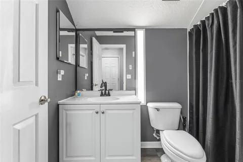 a bathroom with a toilet a sink and mirror