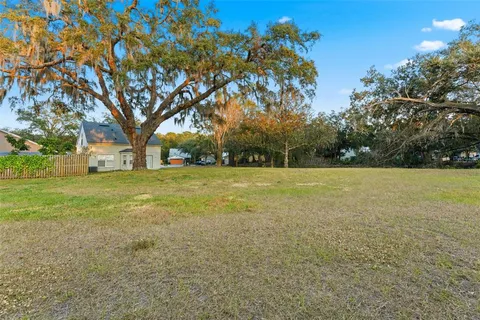 a view of a field with trees in the background