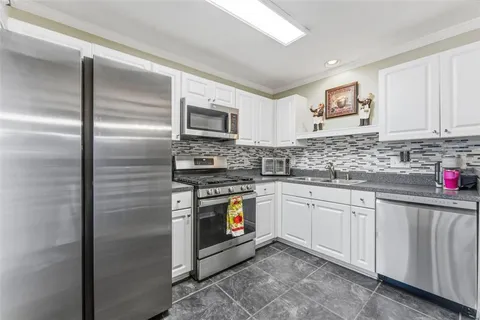 a kitchen with stainless steel appliances granite countertop a stove a sink and a refrigerator