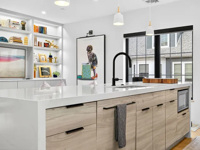 a large white kitchen with stainless steel appliances granite countertop a stove and a sink