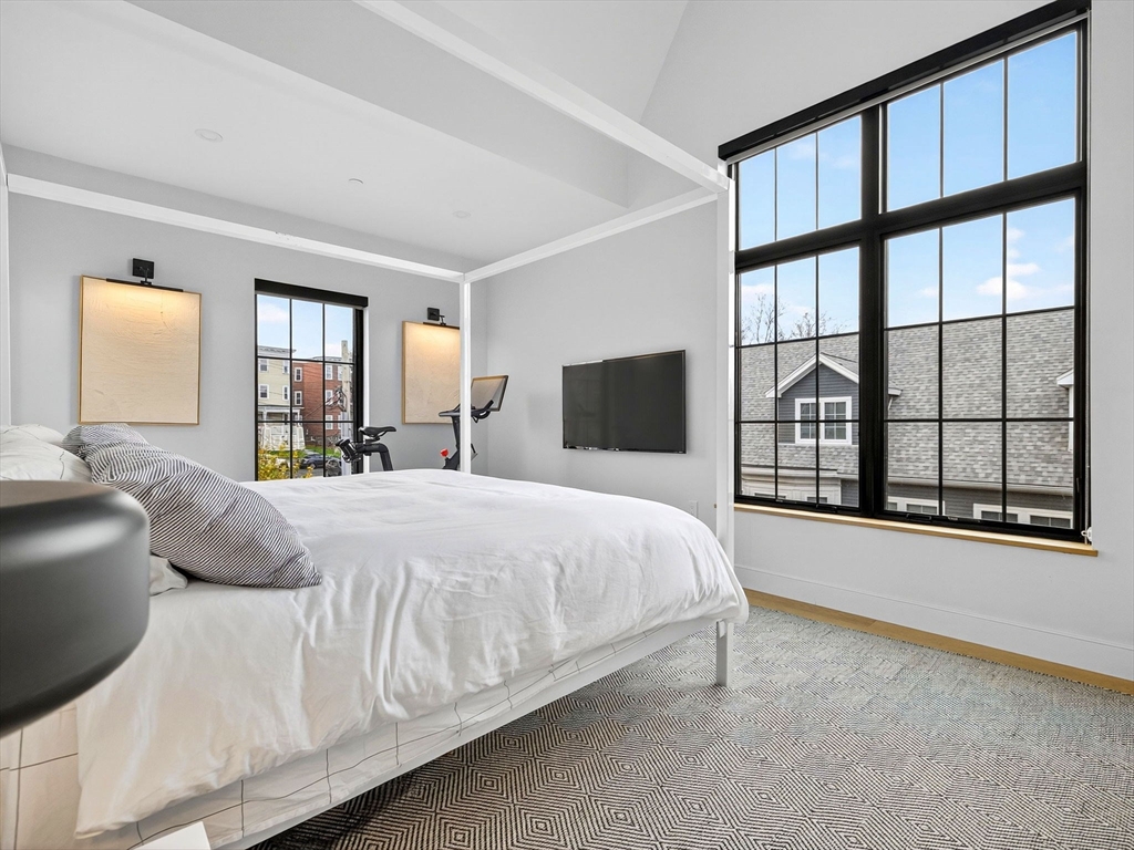 4 Payne Street, Unit FIVE Boston, MA 02122 - Photo 28 of 38 a large bed sitting in a bedroom next to a window