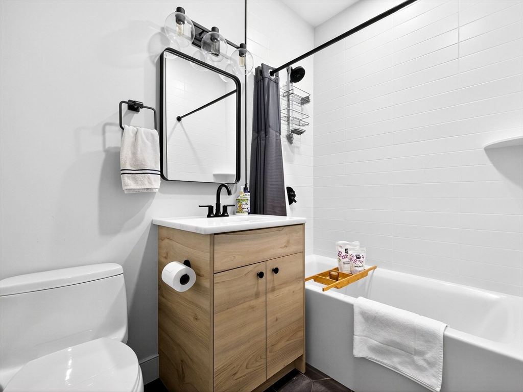 4 Payne Street, Unit FIVE Boston, MA 02122 - Photo 36 of 38 a bathroom with a sink mirror vanity and toilet