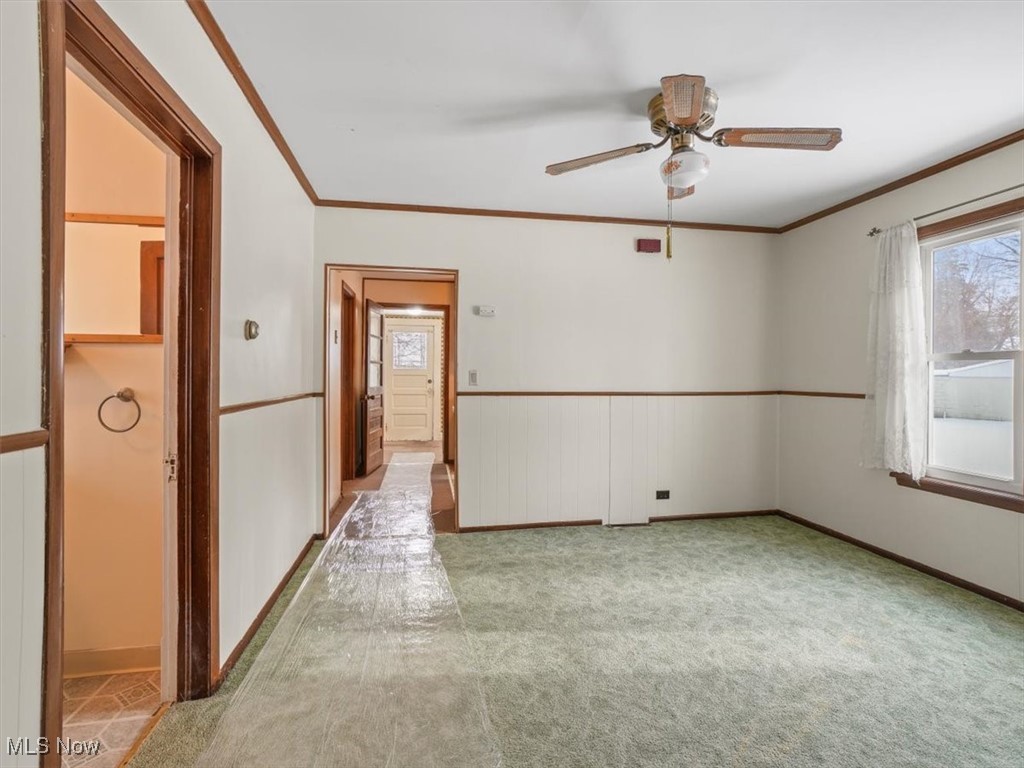 5800 Granger Road Ashtabula, OH 44004 - Photo 10 of 32 Spare room featuring ceiling fan, light carpet, and ornamental molding