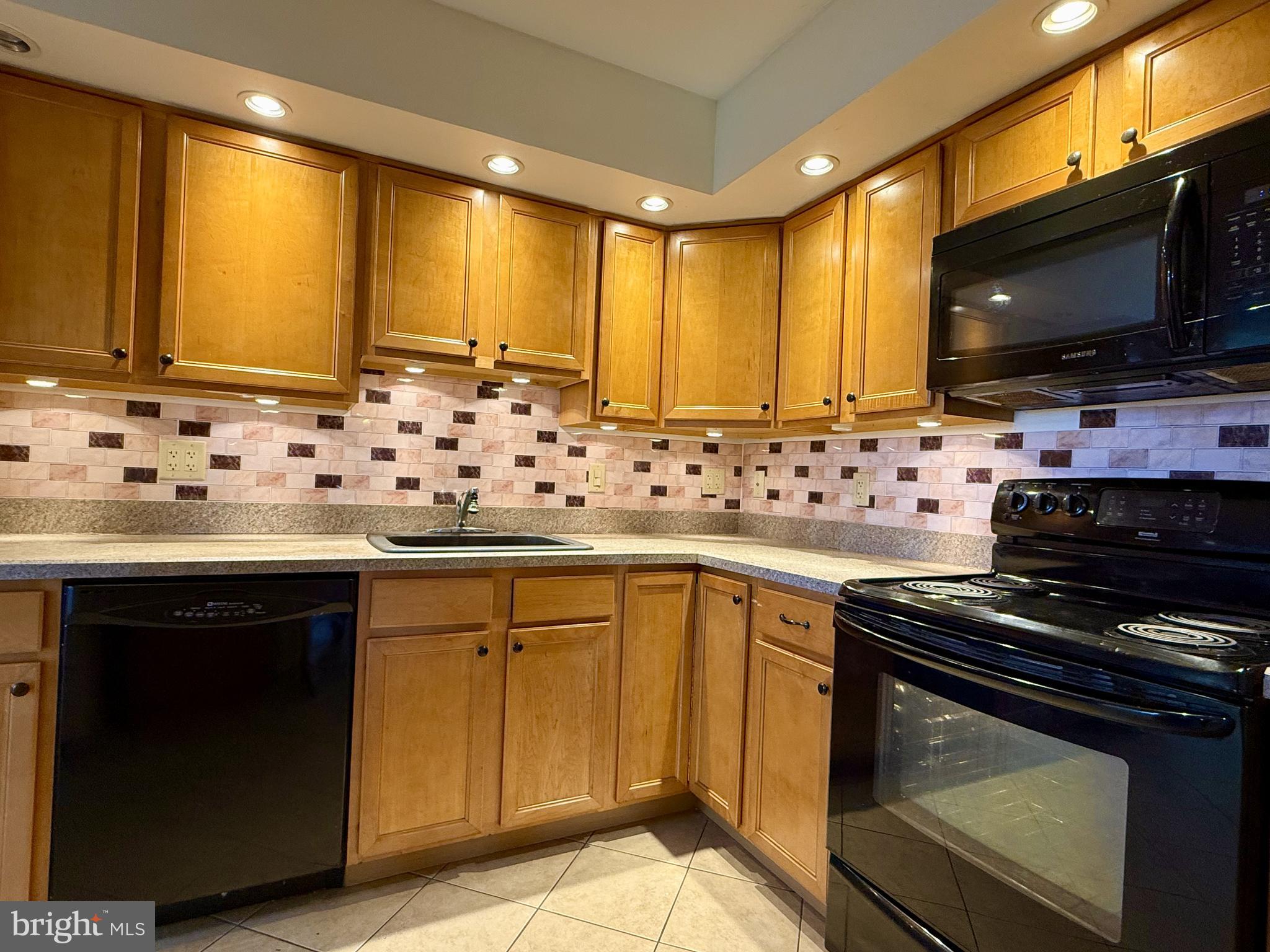 1575 West Street Road, Unit 327 Warminster, PA 18974 - Photo 5 of 17 a kitchen with granite countertop a sink and cabinets