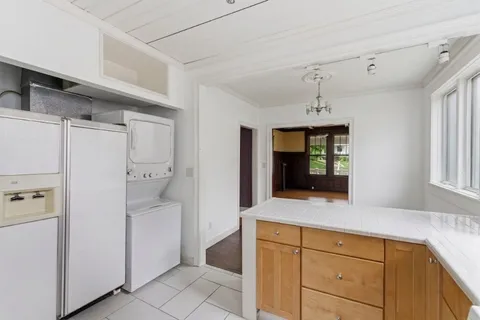 a hallway with cabinets and a refrigerator