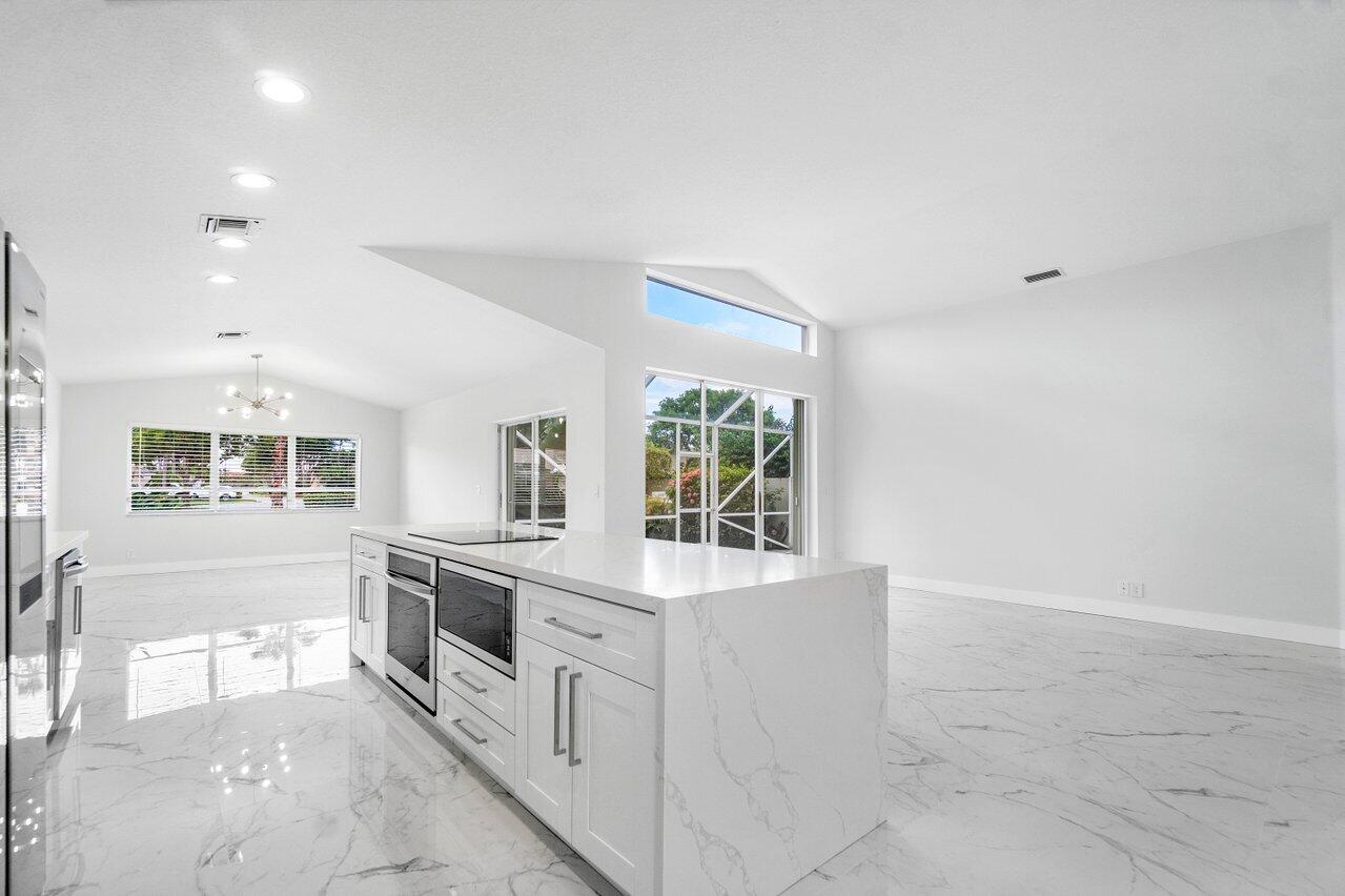 a large white kitchen with cabinets and stainless steel appliances