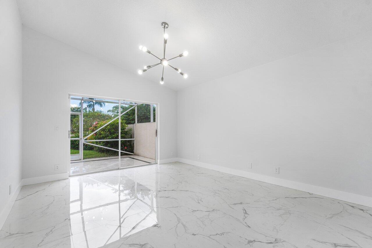 7809 Travelers Tree Drive Boca Raton, FL 33433 - Photo 18 of 33 an empty room with floor to ceiling window and plants