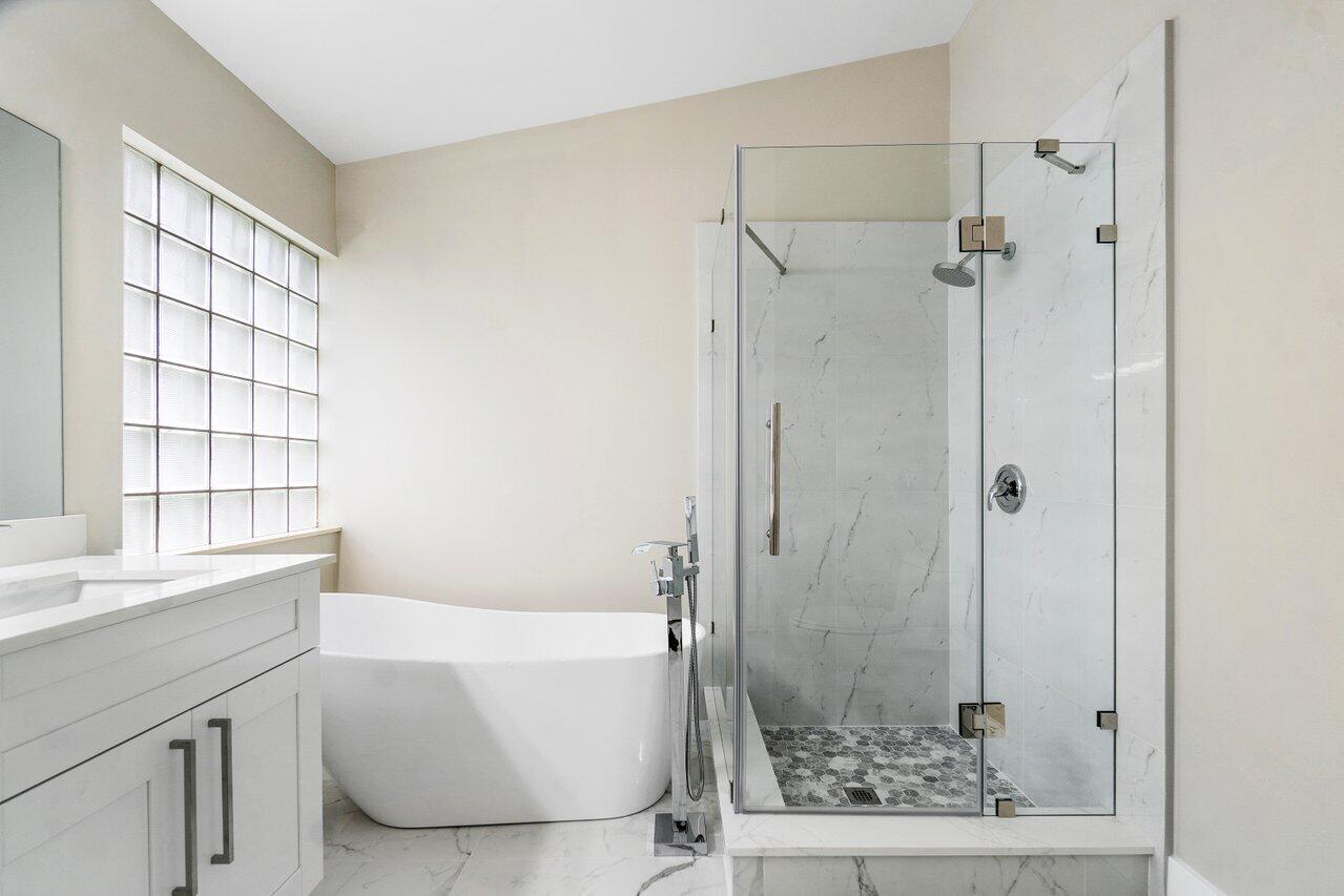 7809 Travelers Tree Drive Boca Raton, FL 33433 - Photo 19 of 33 a bathroom with a bathtub and a shower