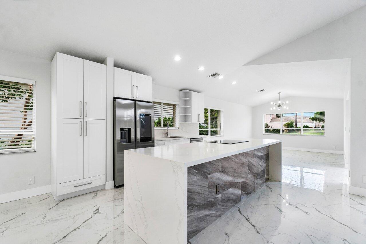 7809 Travelers Tree Drive Boca Raton, FL 33433 - Photo 26 of 33 a large white kitchen with cabinets and a refrigerator