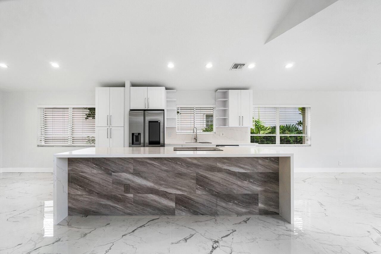 7809 Travelers Tree Drive Boca Raton, FL 33433 - Photo 27 of 33 a large kitchen with kitchen island a sink stainless steel appliances and cabinets