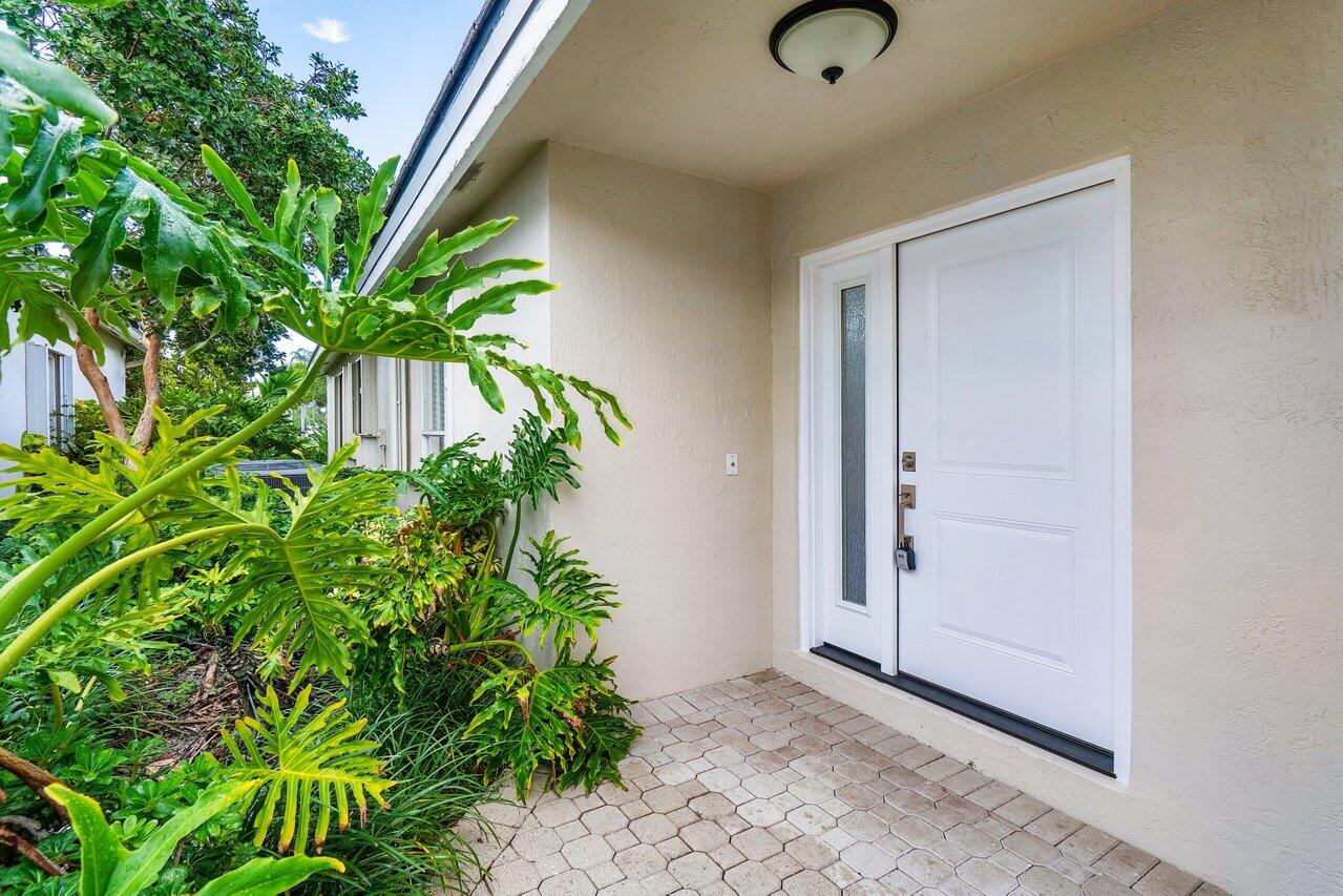 7809 Travelers Tree Drive Boca Raton, FL 33433 - Photo 3 of 33 an entryway with potted plants in front of door