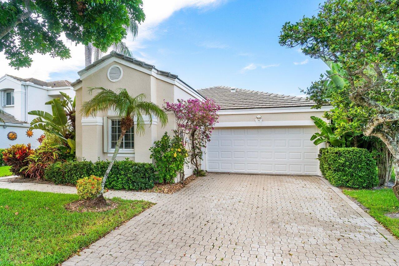 7809 Travelers Tree Drive Boca Raton, FL 33433 - Photo 4 of 33 a front view of a house with garden