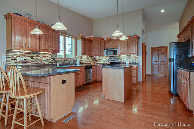 555 Creek Road Plano, IL 60545 - Photo 8 of 25 a kitchen with stainless steel appliances kitchen island granite countertop a stove a sink and a refrigerator