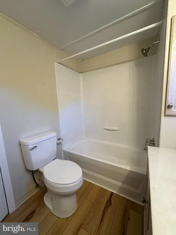 a white toilet sitting next to a bath tub and shower