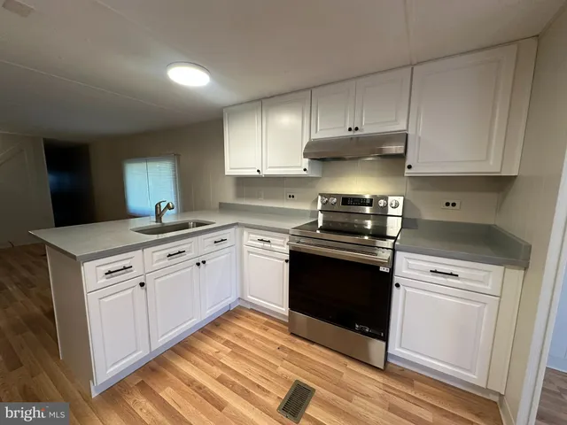 a kitchen with granite countertop white cabinets and appliances