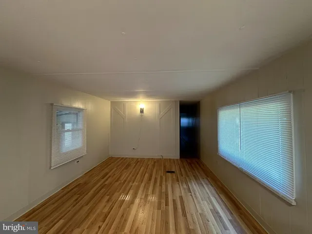 a view of a room with wooden floor and windows