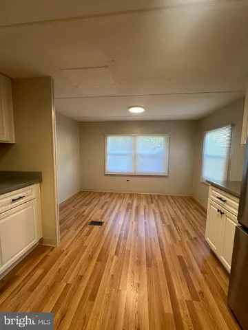 a view of a room with wooden floor and electronic appliances