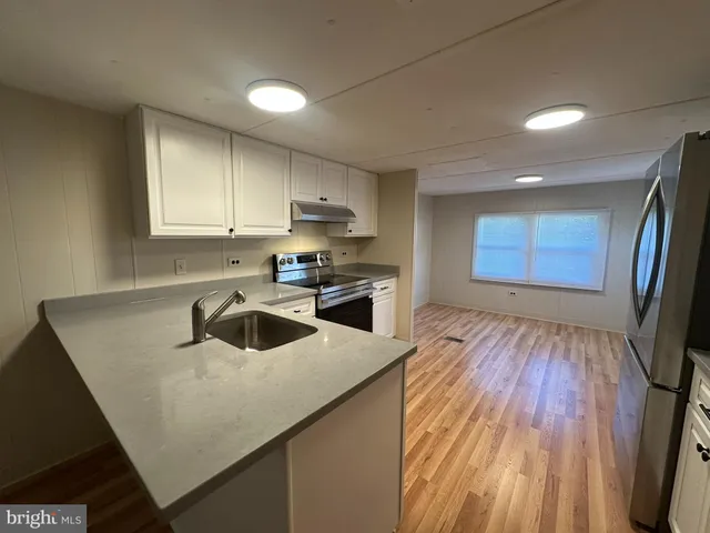 a kitchen that has a microwave a sink and a stove in it