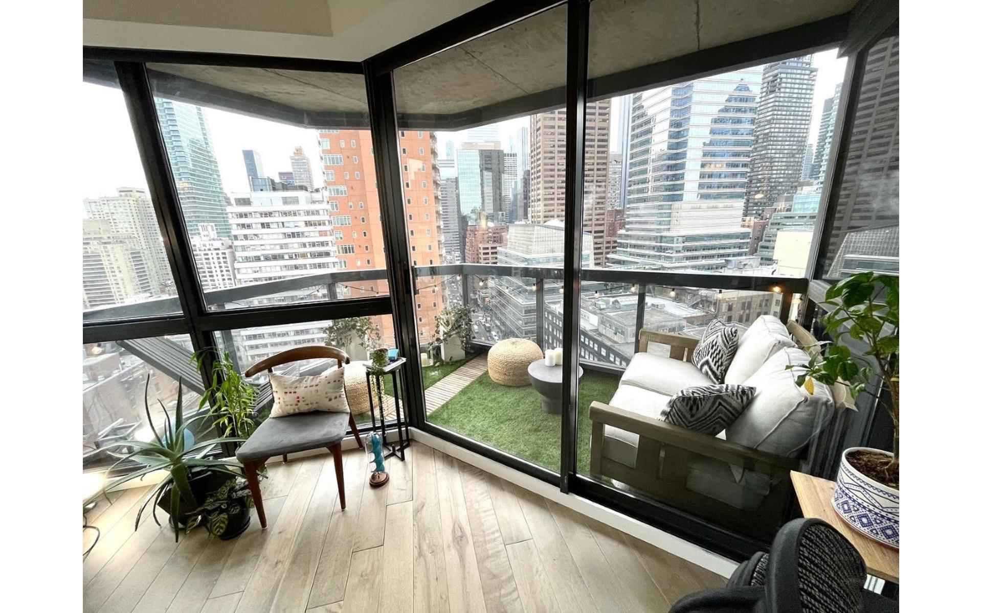 200 East 61st Street, Unit 20A Manhattan, NY 10065 - Photo 7 of 10 a living room with furniture and a large window