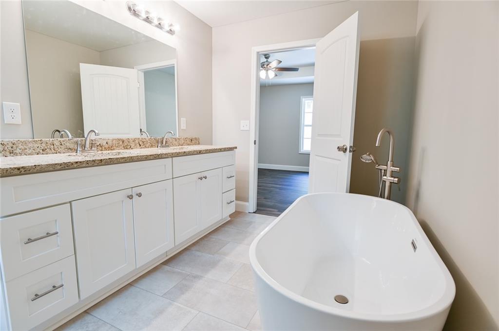 205 Perkins Road Dahlonega, GA 30533 - Photo 12 of 51 a en suite bathroom with a double vanity sink and mirror