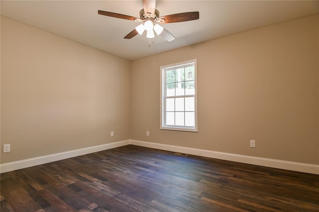 205 Perkins Road Dahlonega, GA 30533 - Photo 23 of 51 an empty room with wooden floor fan and windows