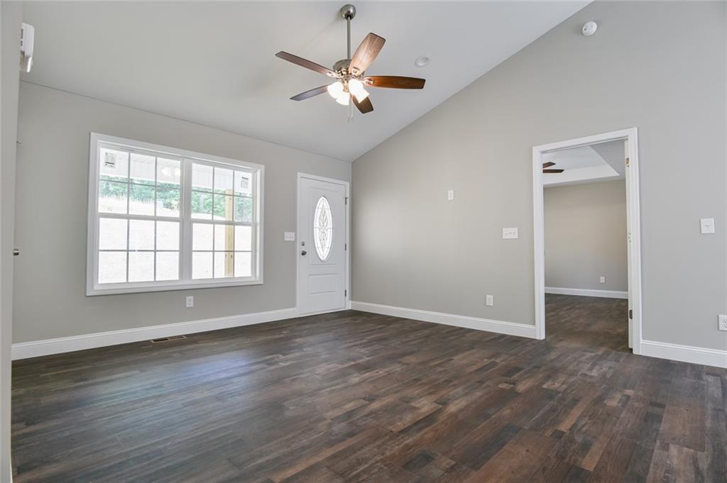 205 Perkins Road Dahlonega, GA 30533 - Photo 3 of 51 a view of an empty room with wooden floor and a window